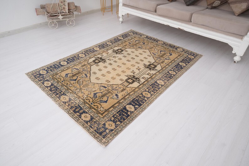 May include: A vintage rug with a cream background and a navy blue border. The rug has a traditional Persian design with intricate floral patterns.