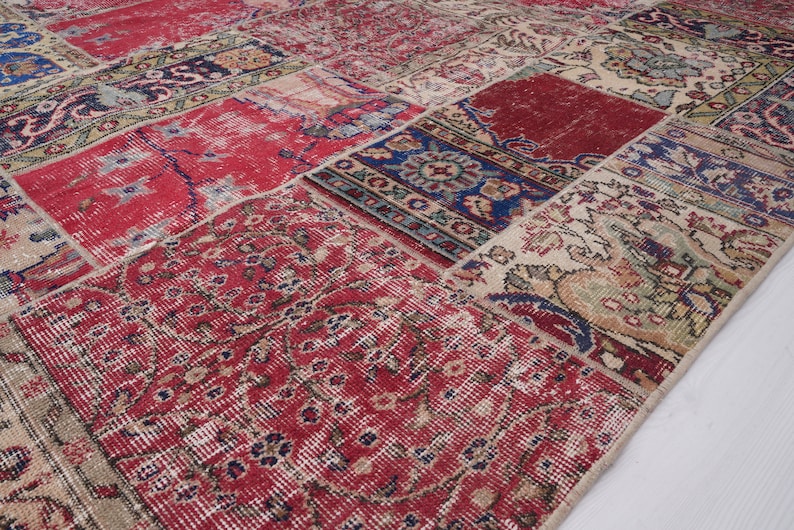 K&ouml;nnte beinhalten: Ein Patchwork-Teppich mit verschiedenen Farben und Mustern, darunter Rot, Blau und Beige. Der Teppich besteht aus verschiedenen Stoffst&uuml;cken, die zusammengen&auml;ht wurden.