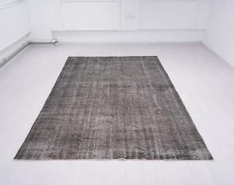 May include: A dark gray vintage rug with a distressed look. The rug has a subtle pattern and a faded appearance.