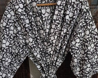 May include: A black and white floral print robe with a tie belt and pockets. The robe has a traditional Japanese kimono style.