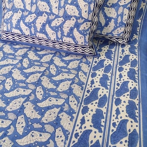 May include: A blue and white cotton bed sheet with a butterfly pattern. The sheet has a border with a geometric design.