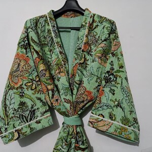 May include: A green floral print robe with white trim. The robe has a long sleeve and a tie belt.