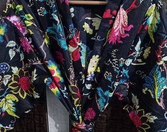 May include: A black floral print robe with a long tie belt. The robe has a white trim around the collar and sleeves.