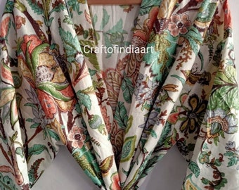 Può includere: Una vestaglia di cotone bianco con stampa floreale in tonalità di verde, rosa e marrone. La vestaglia ha una cintura da legare e maniche lunghe con un bordo verde. Il testo "Craftofindiaart" è visibile sulla vestaglia.