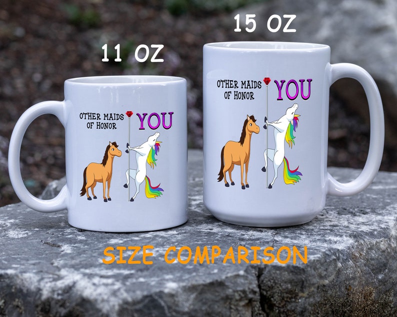 May include: Two white ceramic mugs with a unicorn and horse graphic. The text on the mugs reads "Other maids of honor" and "You". The mugs are shown side-by-side to illustrate the size difference. The smaller mug is 11 oz and the larger mug is 15 oz.