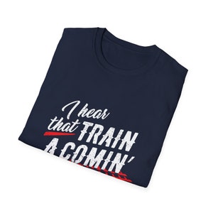 Puede incluir: Una camiseta azul marino con texto blanco que dice "I hear that train a comin'" en una fuente desgastada. El texto se superpone a un gr&aacute;fico rojo y blanco de una v&iacute;a de tren.