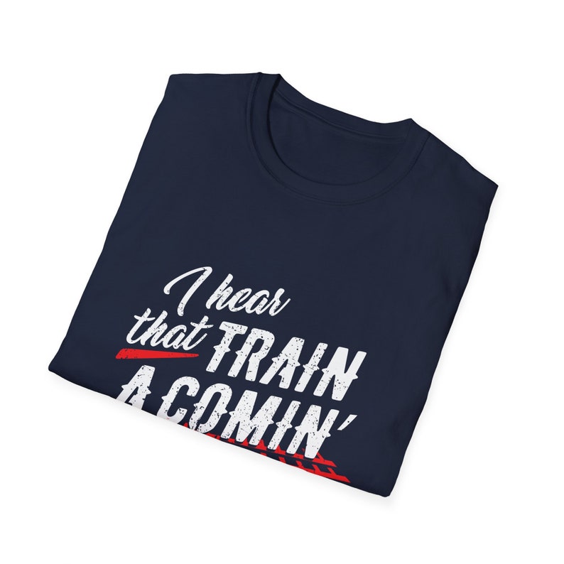 Puede incluir: Una camiseta azul marino con texto blanco que dice "I hear that train a comin'" en una fuente desgastada. El texto se superpone a un gr&aacute;fico rojo y blanco de una v&iacute;a de tren.