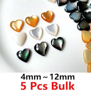 May include: A collection of heart-shaped beads in various colors, including white, iridescent black, and shades of orange. The beads range in size from 4mm to 12mm. The text "4mm ~ 12mm 5 Pcs Bulk" is displayed in red.