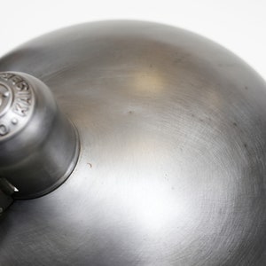 May include: A silver metal desk lamp with a round shade and a knob with the text "Original Design" on it.