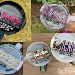 May include: Five different personalized tumbler lids with various glitter and patterned designs. The lids feature names like "Molly", "Kayla", "Jenn", "Lauren", and "Sandra". Each lid has a different design, including space dust glitter, purple glitter, leopard print, bees, and chickens.