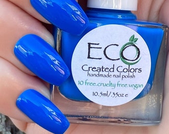 May include: A bottle of bright blue nail polish with a white label that reads "ECO Created Colors handmade nail polish 10 free. cruelty free. vegan. 10.5ml/ .35oz e"