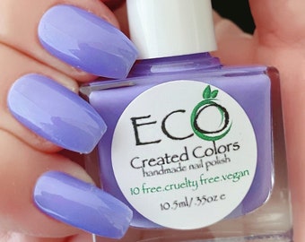 Può includere: Un flacone di smalto per unghie viola con un tappo bianco. Il flacone è etichettato "ECO Created Colors smalto per unghie fatto a mano 10 free. cruelty free. vegan 10,5 ml / 0,35 oz e"