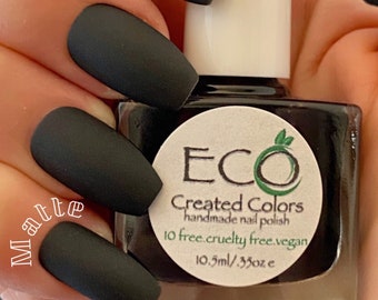 May include: Matte black nail polish in a glass bottle with a white label that says "ECO Created Colors handmade nail polish 10 free. cruelty free. vegan 10.5ml/.35oz e".