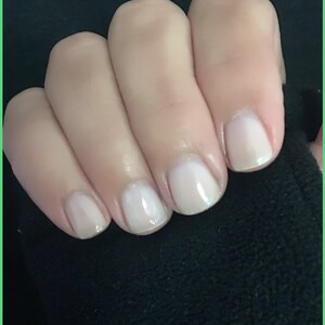 May include: Close-up of five fingernails with a light pink nail polish.