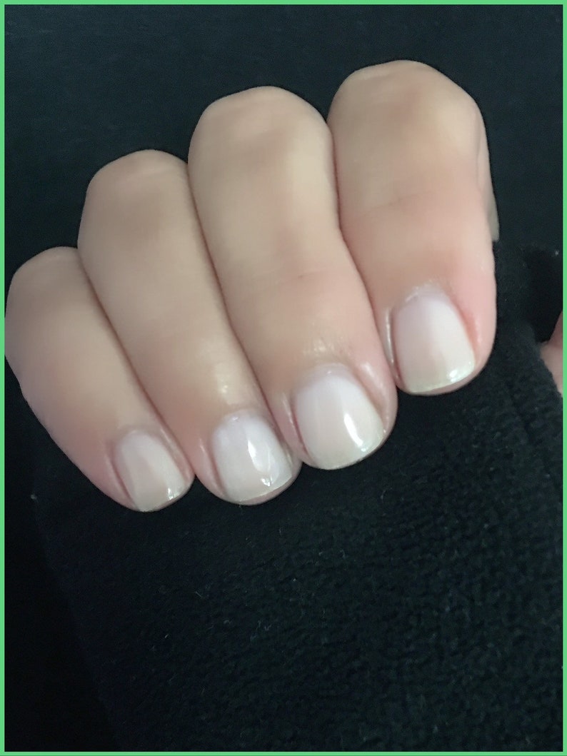 May include: Close-up of five fingernails with a light pink nail polish.