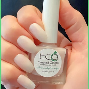 K&ouml;nnte beinhalten: Eine wei&szlig;e Nagellackflasche mit einem wei&szlig;en Deckel. Die Flasche hat ein Etikett mit der Aufschrift "ECO Created Colors handgemachter Nagellack 10 free.cruelty free.vegan 10.3ml/.35oz e".
