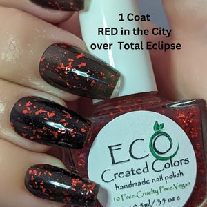Puede incluir: Una botella de esmalte de uñas rojo con un acabado de brillo negro y rojo. La etiqueta de la botella dice "ECO Created Colors esmalte de uñas hecho a mano 10 free Cruelty free. Vegan 10,5 ml / 0,35 oz"