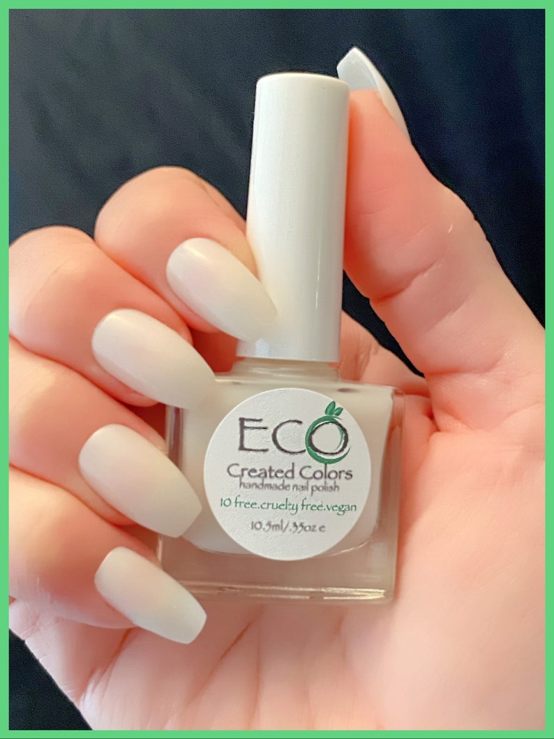 May include: A white bottle of nail polish with a white label that says "ECO Created Colors handmade nail polish 10 free. cruelty free. vegan. 10.5ml/.35oz e"