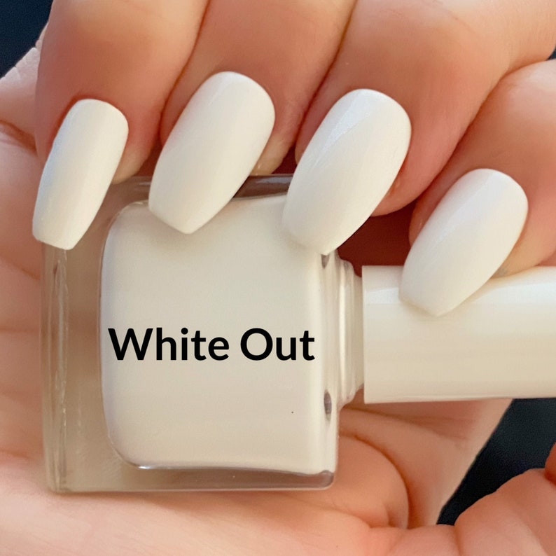 May include: White nail polish bottle with the label "White Out" and a hand with white nail polish on all fingers.