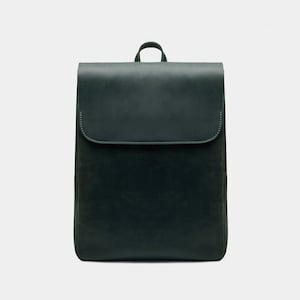 Puede incluir: Una mochila de cuero verde oscuro con cierre de solapa y un pequeño asa superior. La bolsa tiene forma rectangular con esquinas redondeadas y un diseño minimalista. El cuero parece tener un acabado mate.