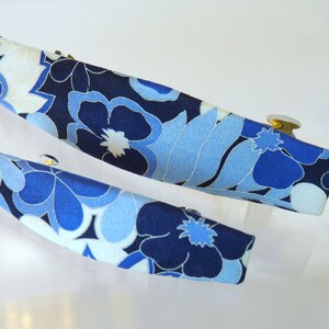 May include: Two blue and white floral patterned hair clips with gold metal clasps.