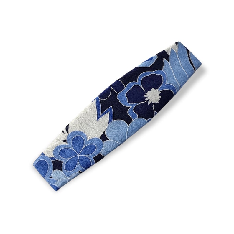 May include: A blue and white floral patterned fabric headband. The headband is made of a soft, comfortable material and is perfect for adding a touch of style to any outfit.