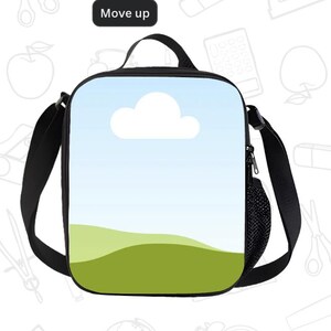Puede incluir: Una bolsa de almuerzo negra con una correa para el hombro y un asa. La parte delantera de la bolsa presenta una escena de cielo con una nube blanca y colinas verdes. El texto "Move up" est&aacute; en un rect&aacute;ngulo negro en la parte superior.