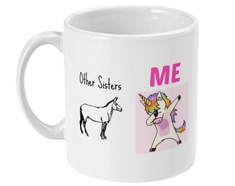 Puede incluir: Taza de cerámica blanca con una ilustración en blanco y negro de un caballo en el lado izquierdo y un unicornio de dibujos animados colorido haciendo el dab en el lado derecho. El texto "Other Sisters" está sobre el caballo y "ME" está sobre el unicornio.