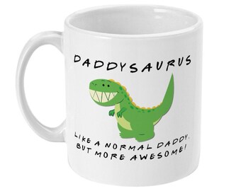 Può includere: Una tazza in ceramica bianca con un'illustrazione di dinosauro verde e il testo "Daddysaurus Like a normal daddy, but more awesome!"