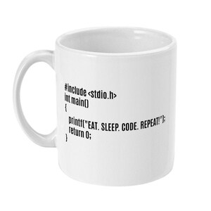 Könnte beinhalten: Weiße Keramiktasse mit schwarzem Text, der lautet: "#include <stdio.h> int main() { printf("EAT. SLEEP. CODE. REPEAT!"); return 0; "}
