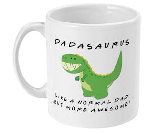 Può includere: Una tazza in ceramica bianca con un dinosauro verde di cartone animato e il testo "Dadasaurus Like a normal dad, but more awesome!"