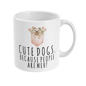 May include: White ceramic mug with a cartoon pug in a pink pocket with flowers. The mug has the text "Cute dogs. Because people are meh!"