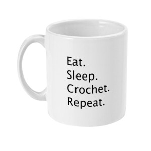 May include: White ceramic mug with black text that reads "Eat. Sleep. Crochet. Repeat."