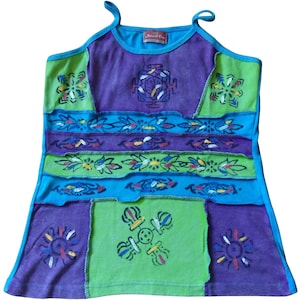 May include: A multi-coloured tank top with a patchwork design. The top is made of cotton and has a relaxed fit. The top features a variety of colours, including purple, blue, green, and yellow. The top is decorated with a variety of patterns, including flowers, leaves, and geometric shapes. The top has a scoop neck and thin straps. The top is made by Natural Feel.