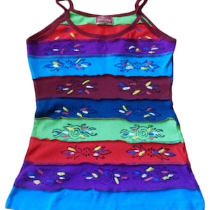 May include: A multi-coloured tank top with a striped design and embroidered floral patterns. The tank top has a scoop neck and thin straps.
