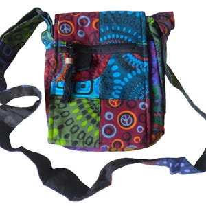 May include: A colourful patchwork shoulder bag with a peace sign design. The bag has a black adjustable strap and a zip closure.