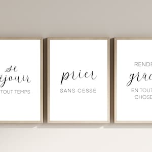 May include: Three framed art prints with inspirational quotes in French. The first print says "Se réjouir en tout temps", the second says "prier sans cesse", and the third says "rendre grâces en toutes choses". The frames are light brown.