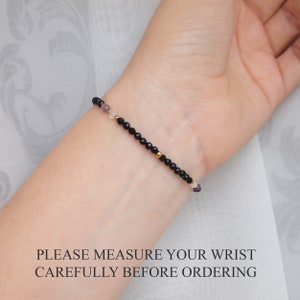 May include: A delicate bracelet with black onyx beads, gold spacers, and small purple and white beads. PLEASE MEASURE YOUR WRIST CAREFULLY BEFORE ORDERING.