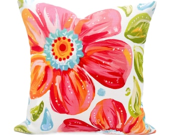 May include: A white pillow with a floral pattern. The flowers are pink, orange, and red with blue and yellow accents. The pillow is perfect for adding a pop of color to any room.