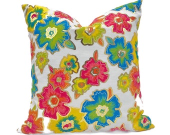 May include: A white pillow with a colorful floral pattern. The flowers are in shades of pink, yellow, blue, and green. The pillow is made of a soft, textured fabric.