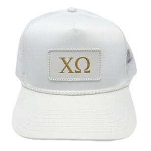 May include: White trucker hat with a white front panel, a white brim, and a mesh back. The hat features a gold rectangular patch with the Greek letters XΩ.