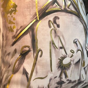 May include: A beige throw pillow with a gold and brown illustration of the nativity scene. The illustration features a star, a manger, and three figures.