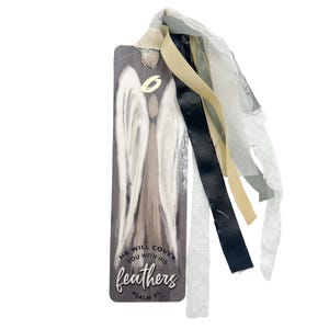 May include: A gray wooden bookmark with a painted angel and the text "He will cover you with his feathers Psalm 91". The bookmark has a white, gray, and black ribbon attached.