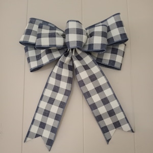 May include: A large blue and white gingham bow with two long tails.