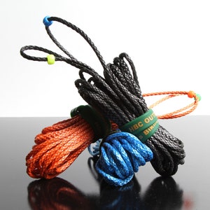 May include: Three spools of rope in black, orange and blue. The spools are tied together with green bands that say "HBC OUTDOORS" and "BIKINI BOTTOM".