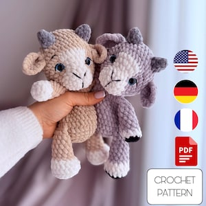 Könnte beinhalten: Zwei gehäkelte Ziegenplüschtiere, eines in Beige und eines in Lavendel, werden in einer Hand gehalten. Die Ziegen haben weiße Gesichter, blaue Augen und kleine Hörner. Der Text "CROCHET PATTERN" ist in einem weißen Rechteck zu sehen.