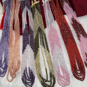 May include: A collection of beaded necklaces in various colors, including purple, peach, silver, olive green, pink, and red. Each necklace features multiple strands of small, faceted beads, with decorative clasps and tassels.