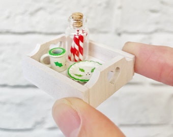 Miniature dollhouse wooden heart tray with Christmas decor, jar of candy canes and festive holly print mug and plate