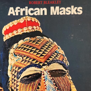 Libro antiguo “Máscaras africanas”: 40 láminas en color con un mapa de África que muestra la ubicación de las tribus