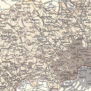 May include: Antique map of London and surrounding areas, featuring detailed roads, railways, and place names. The map is in sepia tones, with a focus on the city center and the Thames River. A historical cartographic piece.